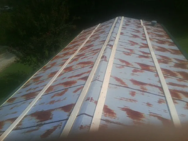 Rusted metal roof panels with new wood purlins before replacement — Storm Damage Roof Repair in Westwood by Roofing Brothers